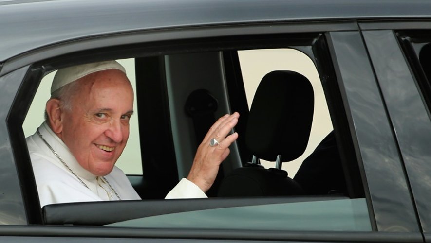 Assis à l'arrière de la Fiat, le pape François salue à son arrivée à Andrews Air Force Base aux Etats-Unis le 22 septembre 2015