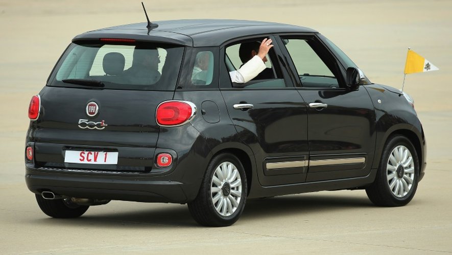Assis à l'arrière de la Fiat, le pape François salue à son arrivée aux Etats-Unis le 22 septembre 2015 à Andrews Air Force Base