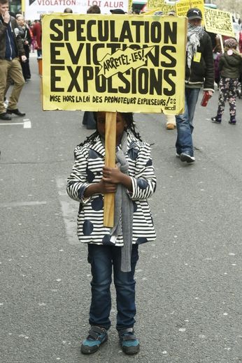 Une enfant brandit une pancarte lors de la manifestation contre les expulsions après la fin de la trêve hivernale, à Paris le 2 avril 2016