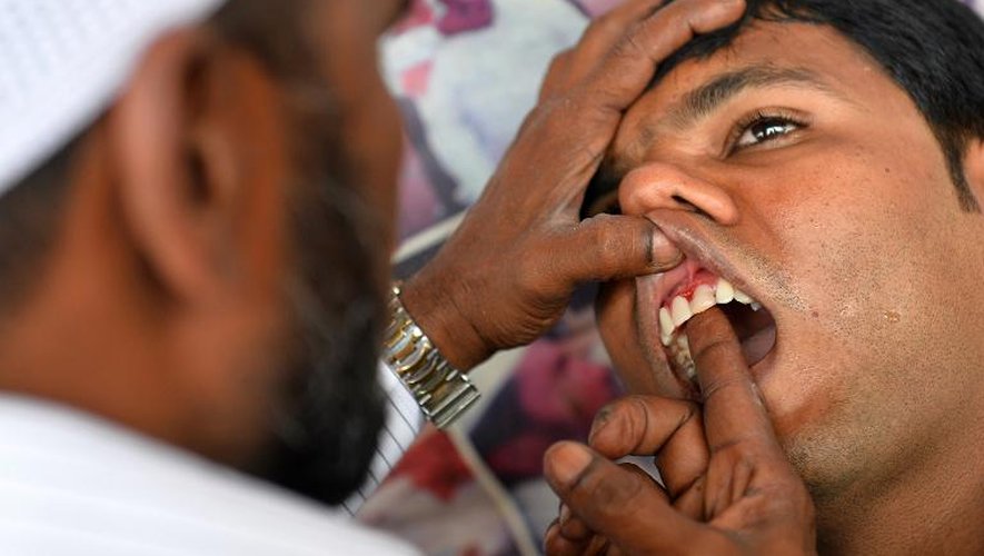 Allah Baksh, dentiste de rue, ajuste une prothèse dentaire le 5 mai 2015 à Bangalore