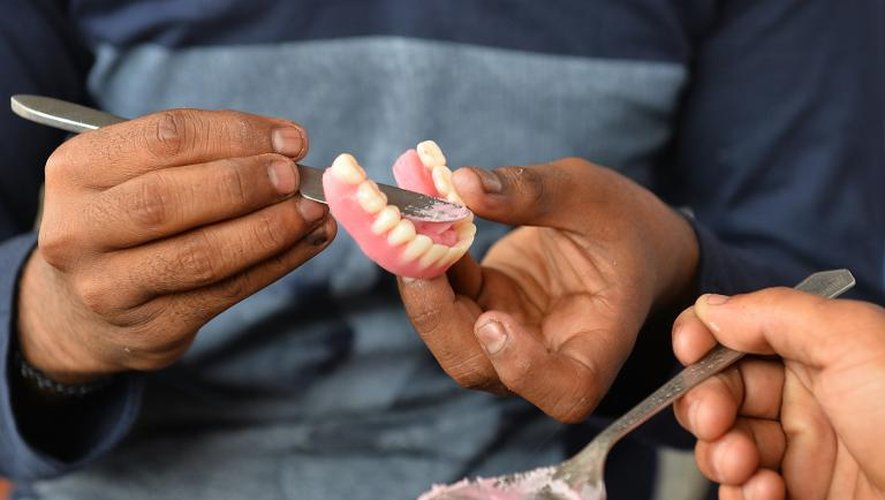 Allah Baksh, dentiste de rue, prépare une protèse dentaire le 5 mai 2015 à Bangalore
