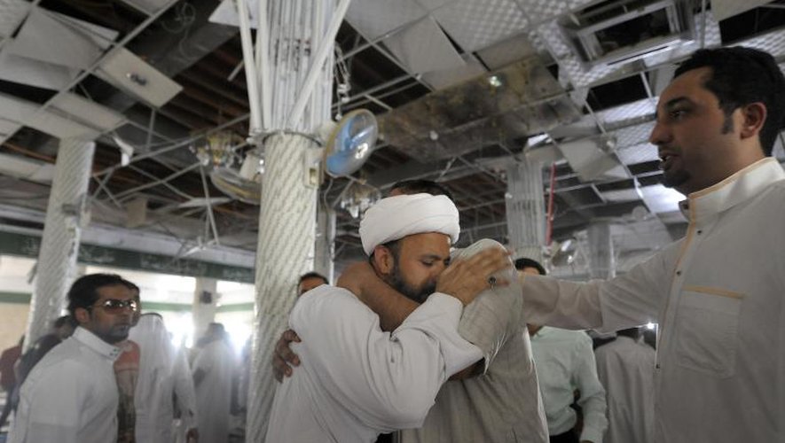 Des hommes se réconfortent dans une mosquée chiite de Koudeih, frappée par une attaque-suicide, le 22 mai 2015