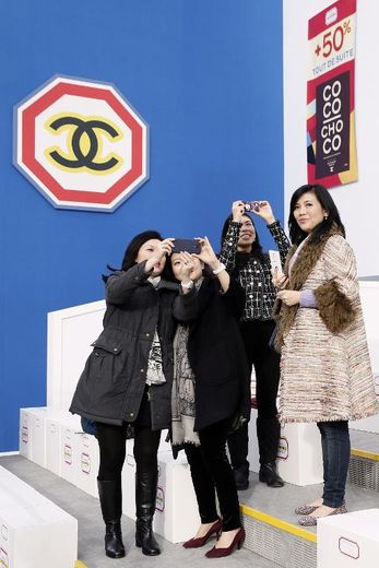 Les invités se prennent en photo dans le décor de supermarché imaginé par la maison Chanel pour présenter sa collection, mardi 4 mars 2014