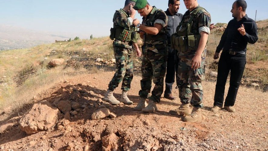 Des soldats constatent les cratères laissés par une roquette tirée depuis la Syrie, atteignant la région de la Bekaa, au Liban, le 1er juin 2013
