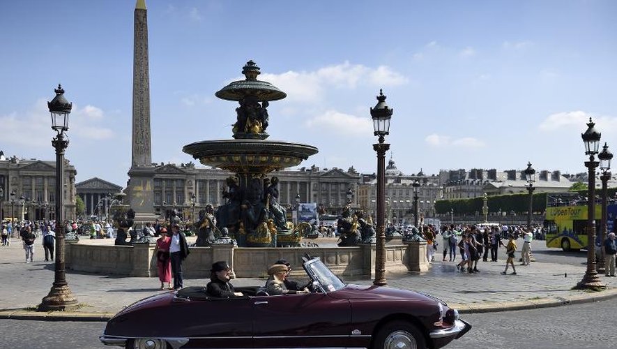 Une Citroën DS circule Place de la Concorde à Paris le 24 mai 2015 pour célébrer les 60 ans de cette automobile emblématique de la France conquérante des Trente glorieuses