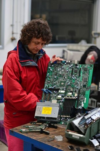 Une ancienne employée de la société Maflow récupère du matériel électronique, le 16 mai 2013, dans l'usine occupée près de Milan