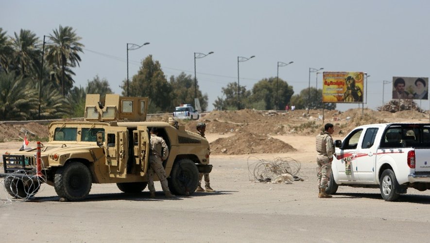 Les forces de sécurité irakiennes sur le site d'une attaque suicide, le 4 avril 2016 près de Bagdad