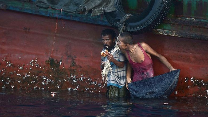 Des migrants rohingyas se nourrissent le 14 mai 2015 avec des aliments lancés depuis un hélicoptère de l'armée thaïlandaise vers le bateau qui les transportait au sud de l'île Koh Lipe dans la mer d'Andaman