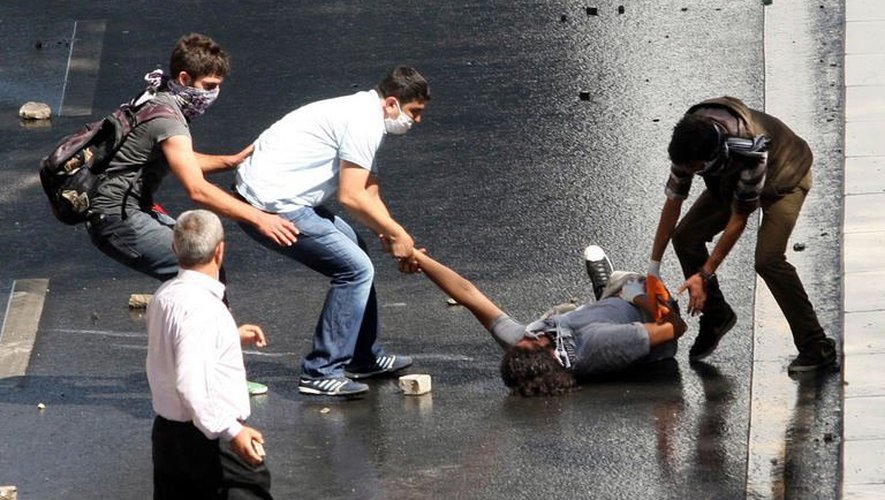 Des manifestants aident un blessé à se relever, en marge des manifestations, à Ankara, le 1er juin 2013
