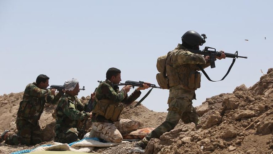 Des soldats irakiens et des miliciens chiites ouvrent le feu contre des positions de l'organisation Etat islamique (EI), le 19 mai 2015 dans le district Garma de la province d'Al Anbar