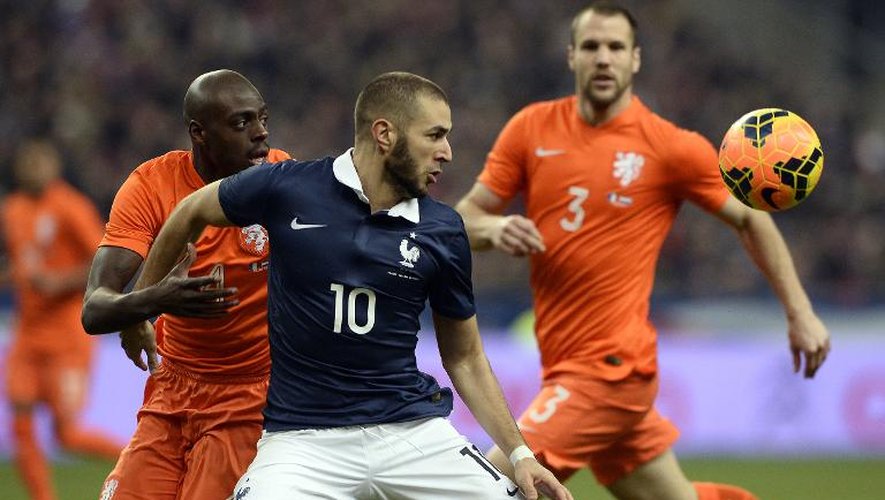L'attaquant de l'équipe de France, Karim Benzema (c), tente de contrôler la balle devant le Néerlandais Martins Indi, le 5 mars 2014 en amical au Stade de France