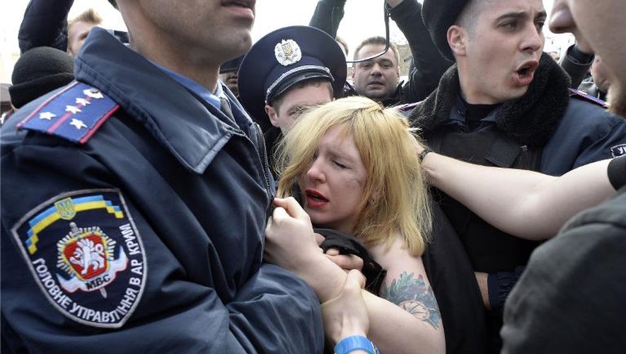 Des policiers ukrainiens arrêtent une manifestante du mouvement Femen, le 6 mars 2014 à Simféropol, la capitale de la Crimée