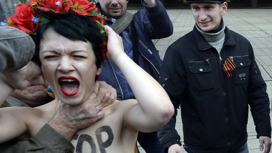 Un homme étrangle une manifestante du mouvement Femen devant le parlement de Crimée à Simféropol, le 6 mars 2014