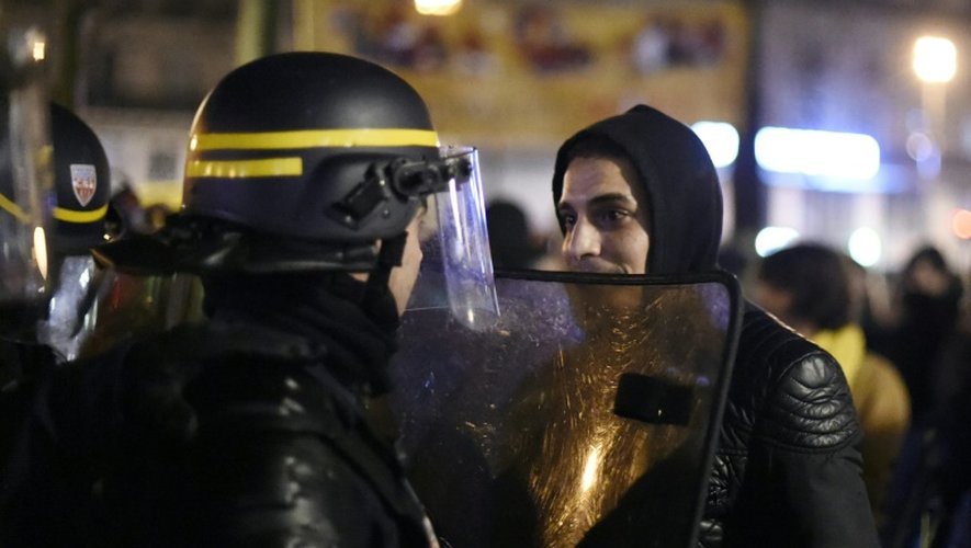 Un participant à la "Nuit debout"face à un policier anti-émeute place de la Republique à Paris le 3 avril 2016
