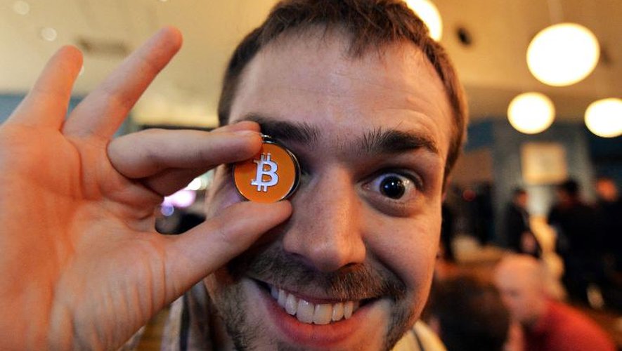 James MacWhyte, un membre du Bitcoin trading club, tenant une médaile à l'effigie de la monnaie virtuelle lors d'une rencontre du club à Tokyo, le 27 février 2014