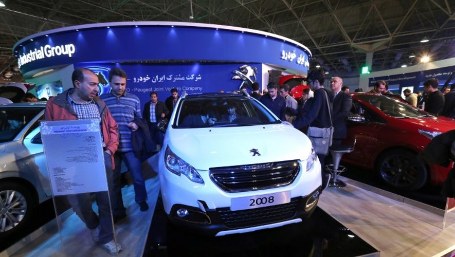 Des visiteurs regardent une Peugeot 208, fabriquée en Iran en collaboration avec le fabricant local Iran Khodro, au salon international de l'automobile à Téhéran le 2 mars 2016