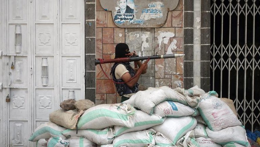 Un membre des milices pro-gouvernementales yéménites en position de combat le 24 avril 2015 dans une rue de la ville de Taëz, théâtre d'affrontements avec les rebelles chiites Houthis