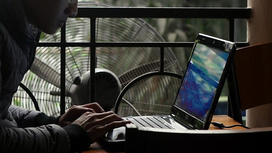 Un homme travaille sur un ordinateur portable dans un café d'Hanoi, au Vietnam