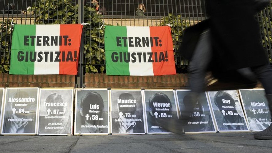 Un home passe devant des   panneaux réclamant "Eternit: Justice" accrochés sur le tribunal de Turin, en décembre 2009