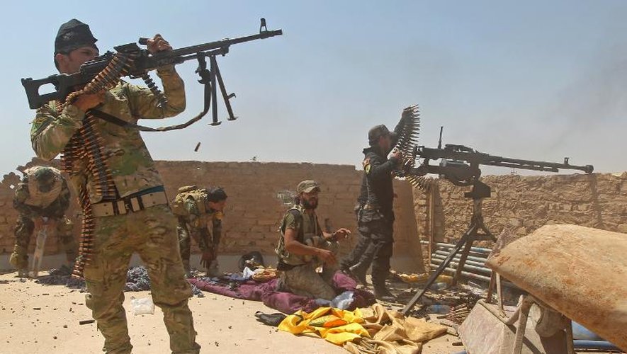 Des miliciens chiites irakiens le 25 mai 2015 au cours d'une opération pour tenter de reprendre une raffinerie de pétrole dans les environs de Baiji, au nord de Tikrit