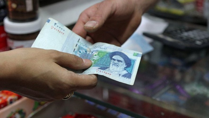 Une femme paie des achats avec un billet de 20.000 rials (70 cents americains) à Téhéran, le 30 septembre 2012