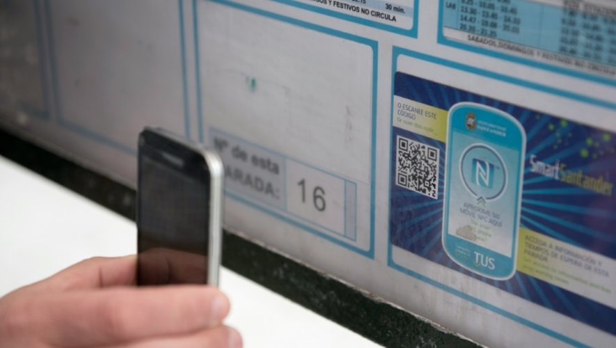Une personne se sert de son son smartphone pour lire un QR code à un arrêt de bus de la ville espagnole de Santander, le 16 mars 2016
