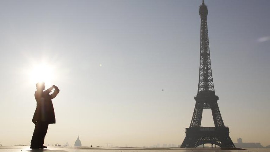 Un touriste photographie la tour Eiffel à Paris le 10 mars 2014
