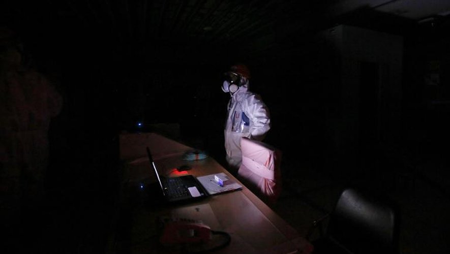 Un employé de Tepco lors d'une simulation de plongée dans le noir de la salle de contrôle des unités 1 et 2 de la centrale atomique Fukushima Daiichi, le 10 mars 2014