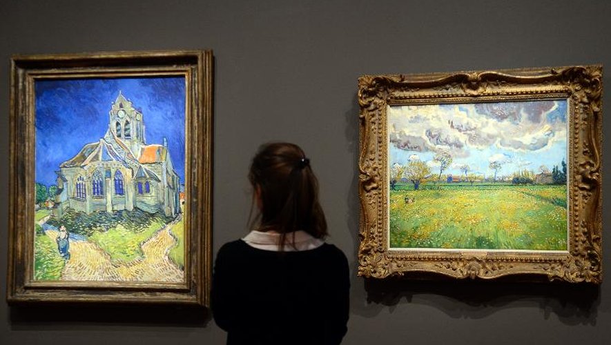 "L'église d' Auvers-sur-Oise vue du chevet" (G) et "Paysage sous un ciel tourmenté" de Van Gogh, exposés au Musée d'Orsay à Paris, le 10 mars 2014