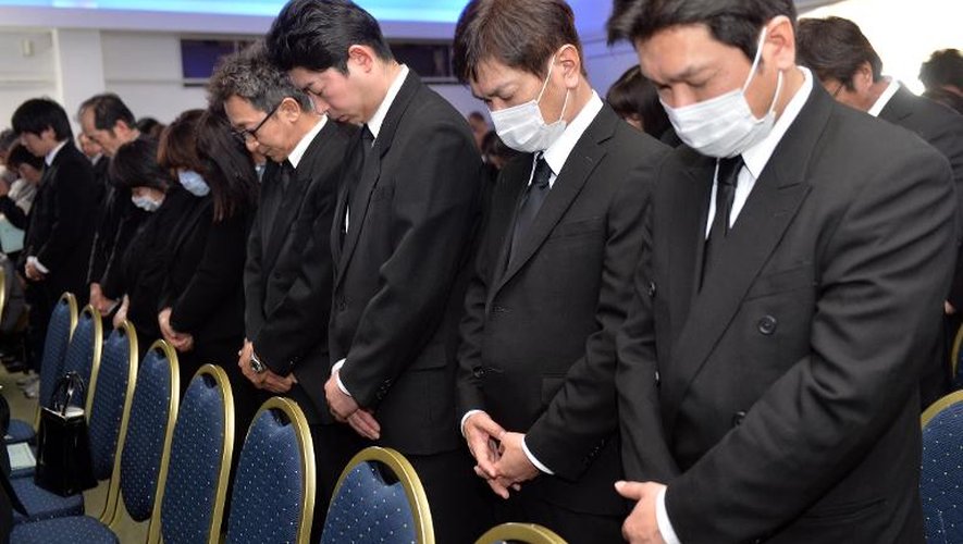 Des Japonais observent une minute de silence en hommage à la mémoire des victimes du tsunami de 2011, à Namie le 11 mars 2014