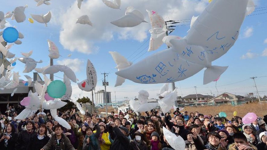 Des Japonais lâchent les ballons en forme de colombes lors d'une cérémonie en hommage aux victimes du tsunami de 2011, à Natori le 11 mars 2014