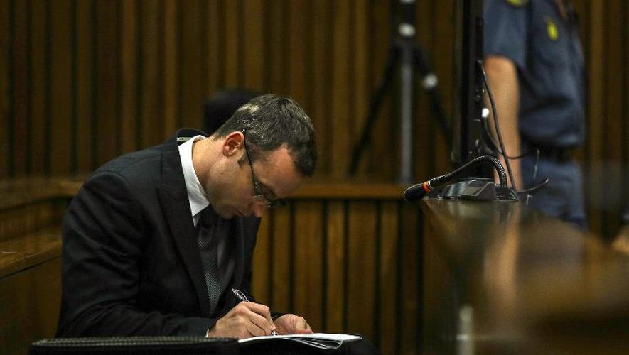 Oscar Pistorius prend des notes lors de son procès, à Pretoria le 11 mars 2014