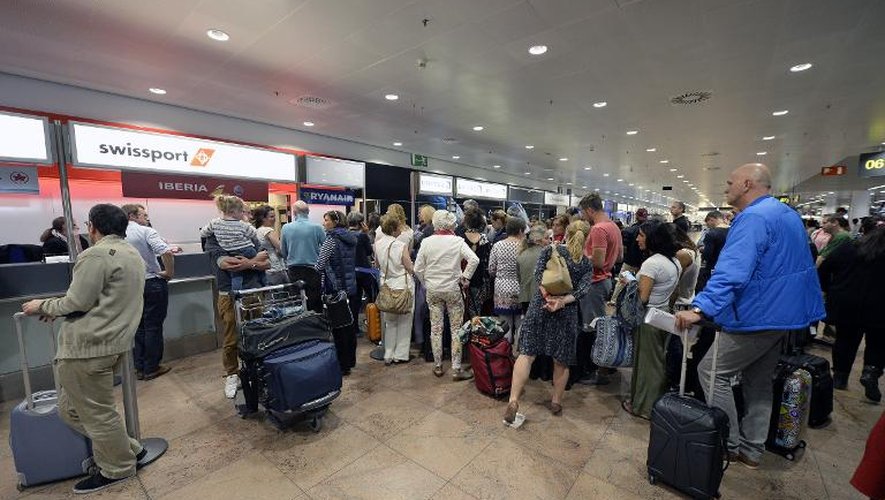 Des passagers font la queue devant le bureau d'information de l'aéroport de Bruxelles, à Zaventem, le 27 mai 2015