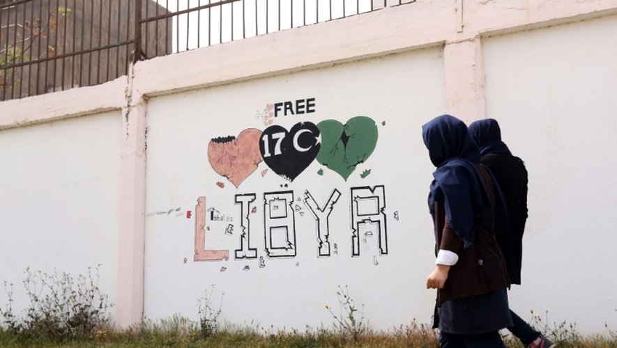 Des étudiants passent à côté d'un graffiti "Libye libre", à Tripoli, le 31 mars 2016