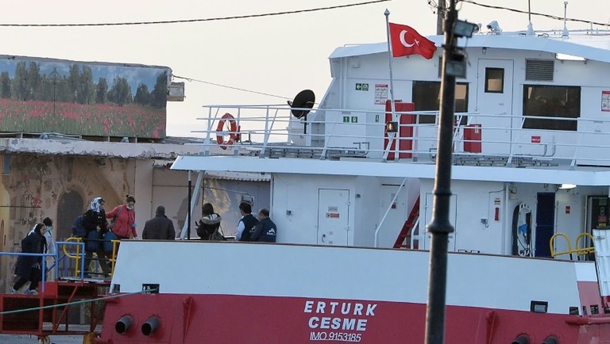 Des migrantes escortées par des agents de Frontex montent à bord du ferry qui doit les emmener en Turquie, le 4 avril 2016 à Chios
