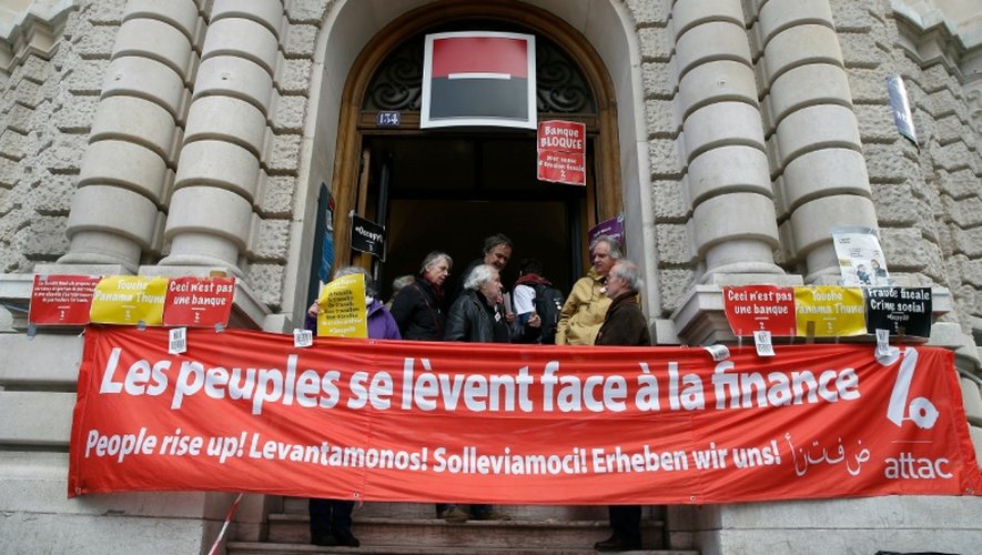 Des membres de l'association Attac bloquent l'entrée d'une agence de la Société Générale à Paris le 7 avril 2016