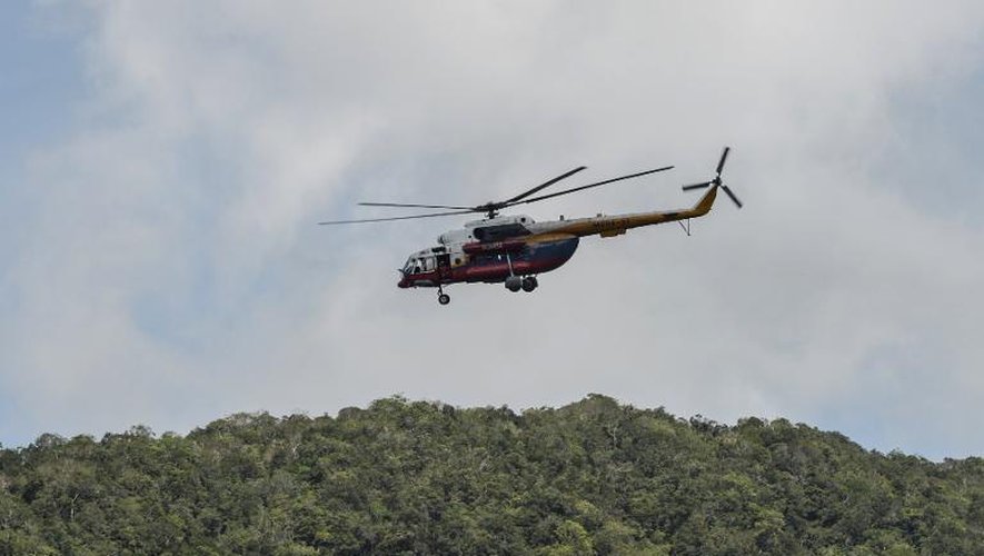 Un hélicoptère de recherche et de secours malaisien survole, le 28 mai 2015, un camp ayant servi à la traite d'êtres humains où des tombes ont été retrouvées à Wang Kelian, à la frontière avec la Thaïlande