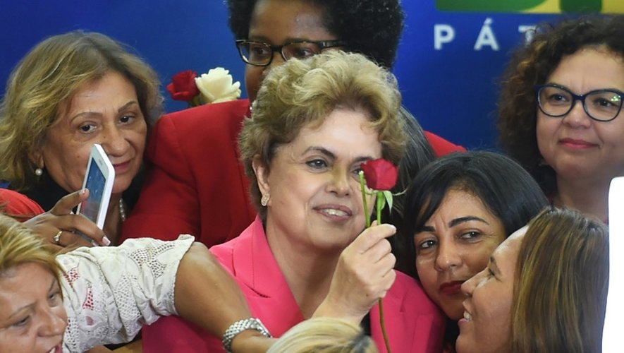 La présidente brésilienne Dilma Rousseff reçoit une rose lors d'une rencontre intitulée "Des femmes en défense de la démocratie" à Brasilia le 7 avril 2016