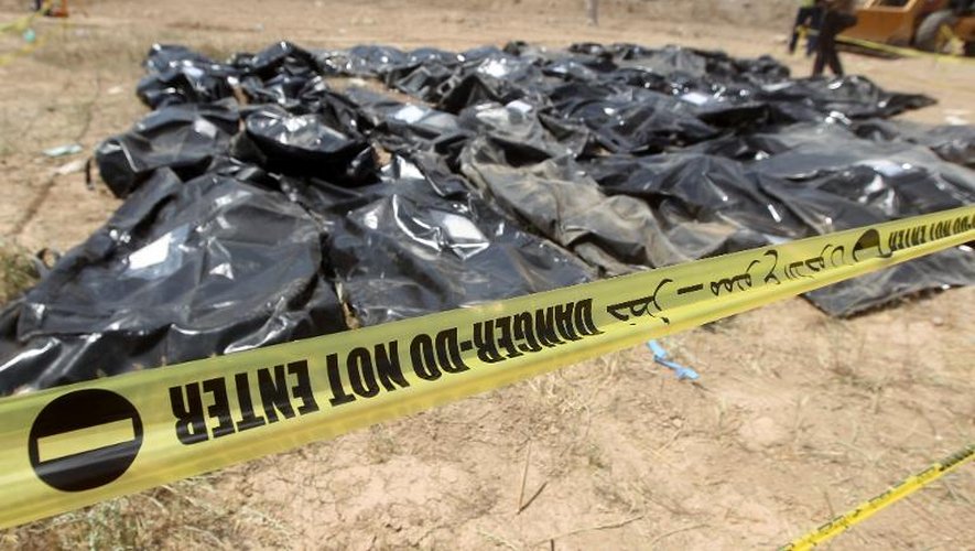 Des sacs contenant les corps de recrues chiites qui auraient été massacrées en 2014 par le groupe EI sont enetreposés sur la base militaire Speicher à Tikrit, en Irak, le 12 avril 2015