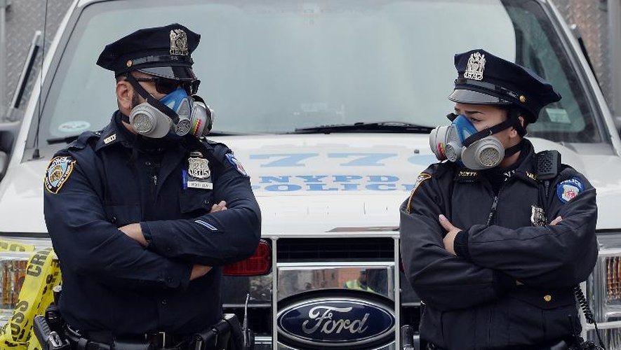 Des officiers de police new-yorkais portent des masques à gaz sur les lieux de l'explosion et de l'effondrement de deux immeubles à Park Avenue le 12 mars 2014