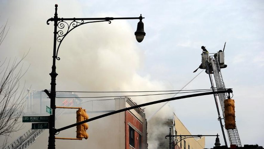 Des pompiers sur les lieux de l'explosion et de l'effondrement de deux immeubles à Park Avenue à New York le 12 mars 2014