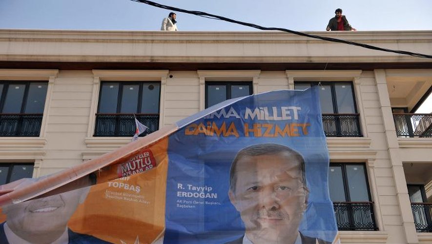 Des manifestants décrochent le portrait du Premier ministre turc Recep Tayip Erdogan à Istanbul le 12 mars 2014