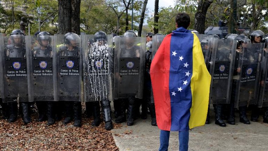 Un étudiant vénézuélien fait face à la police lors d'une manifestation contre le gouvernement à Caracas le 12 mars 2014