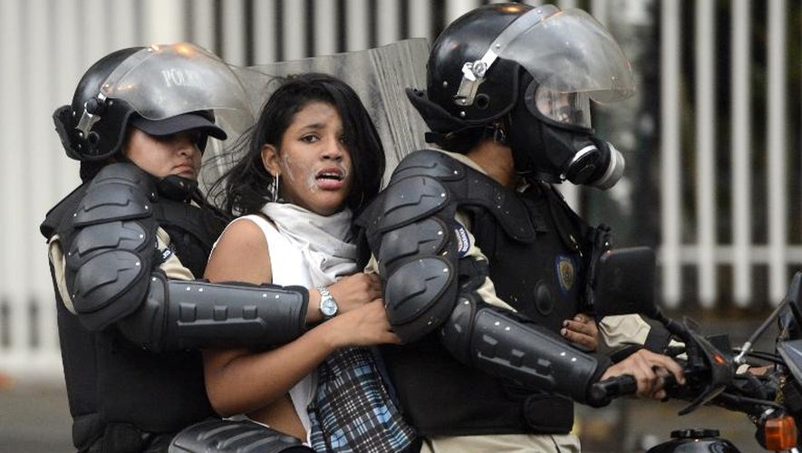 Une manifestante d'opposition est arrêtée par la police nationale lors d'une manifestation à Caracas le 13 mars 2014