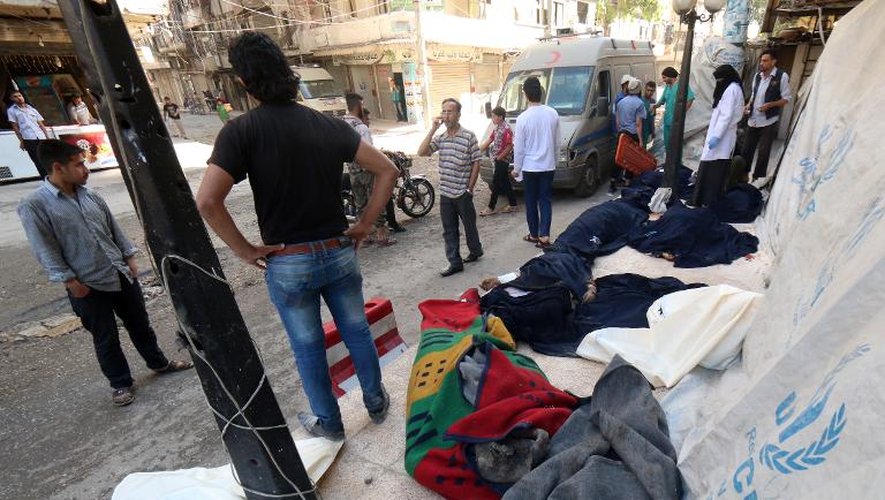 Les corps de victimes présumés de raids aux barils d'explosifs du régime syrien sont entreposés sur un trottoir d'Alep, dans le nord du pays, le 30 mai 2015