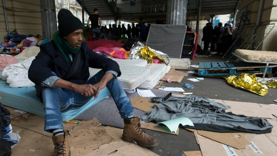 Un migrant assis sur un matelas dans un camp sous la station de métro Stalingrad à Paris le 24 mars 2016