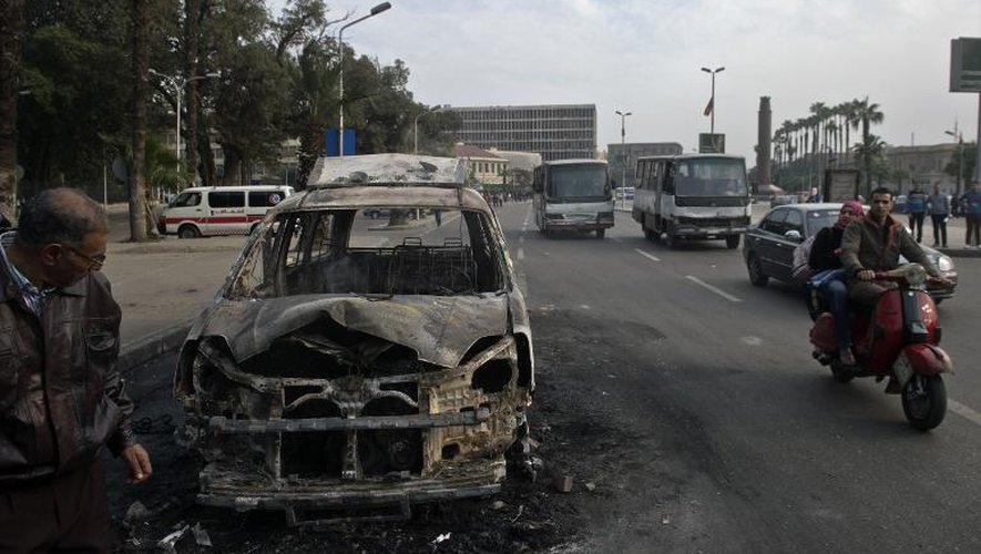 La carcasse calcinée d'un véhicule incendié lors d'incidents le 9 mars 2014 au Caire
