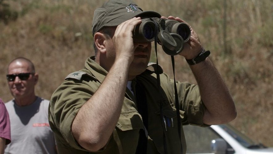 Un officier israélien observe dans le Golan le côté syrien de la frontière près de Qouneitra, le 6 juin 2013