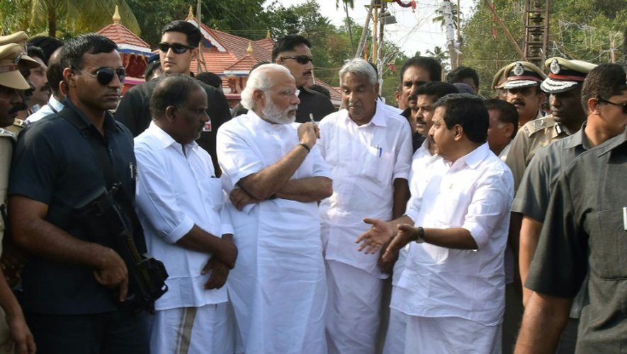 Photo remise par le Bureau de presse indien (PIB) montrant le Premier ministre Narendra Modi (Centre G) sur le site de l'incendie du temple Puttingal à Paravur dans l'Etat du Kerala