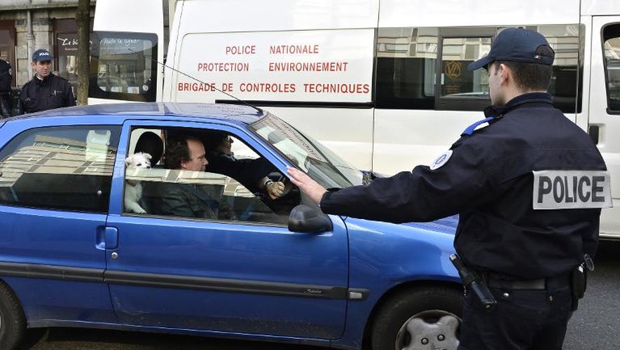 Un policier français arrête une voiture à Lyon le 14 mars 2014 pour vérifier son pot d'échappement